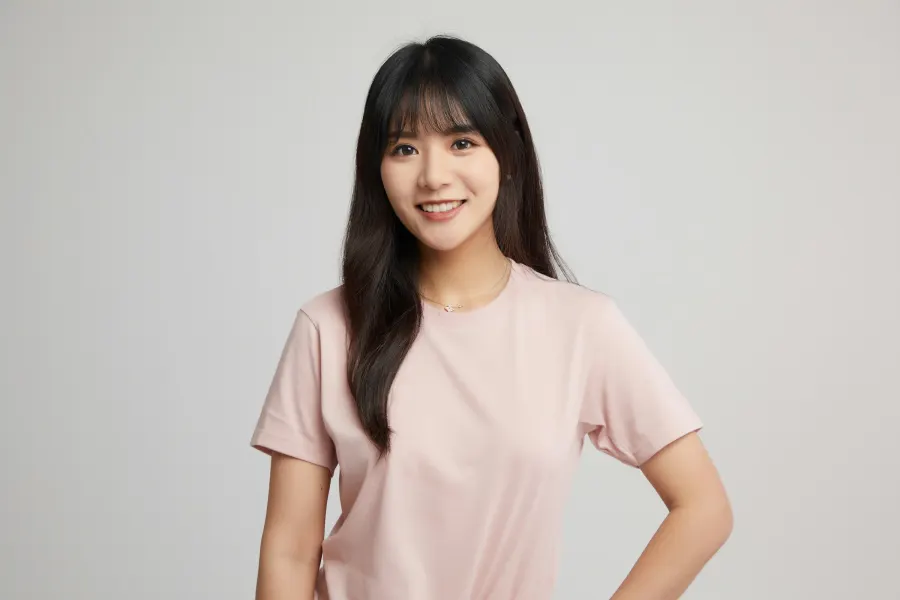 A smiling young woman in a pink T-shirt