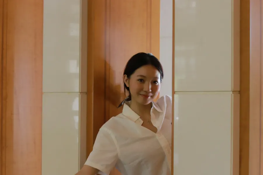 A smiling young woman in a white shirt